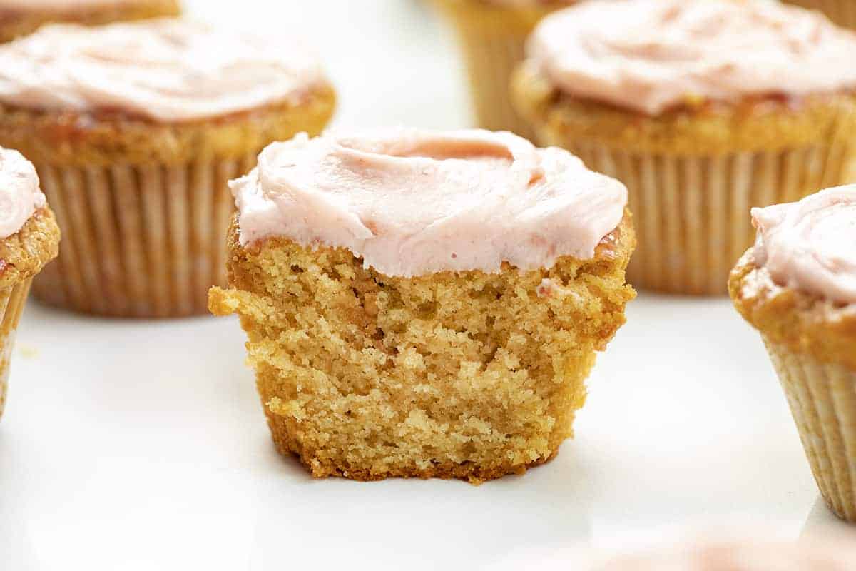 Peanut Butter and Jelly Cupcakes are peanut butter cupcakes topped with a strawberry glaze and covered in sweet, strawberry frosting. PB&J Cupcakes, Peanut Butter Cupcakes, Peanut Butter and Jelly Cupcakes, Jelly frosting, jam frosting, peanut butter & jelly recipes, cupcakes, cupcake recipes, baking, dessert, snacks, popular kids cupcake, i am baker, iambaker, recipes Cut Into Peanut Butter and Jelly Cupcake Showing Inside