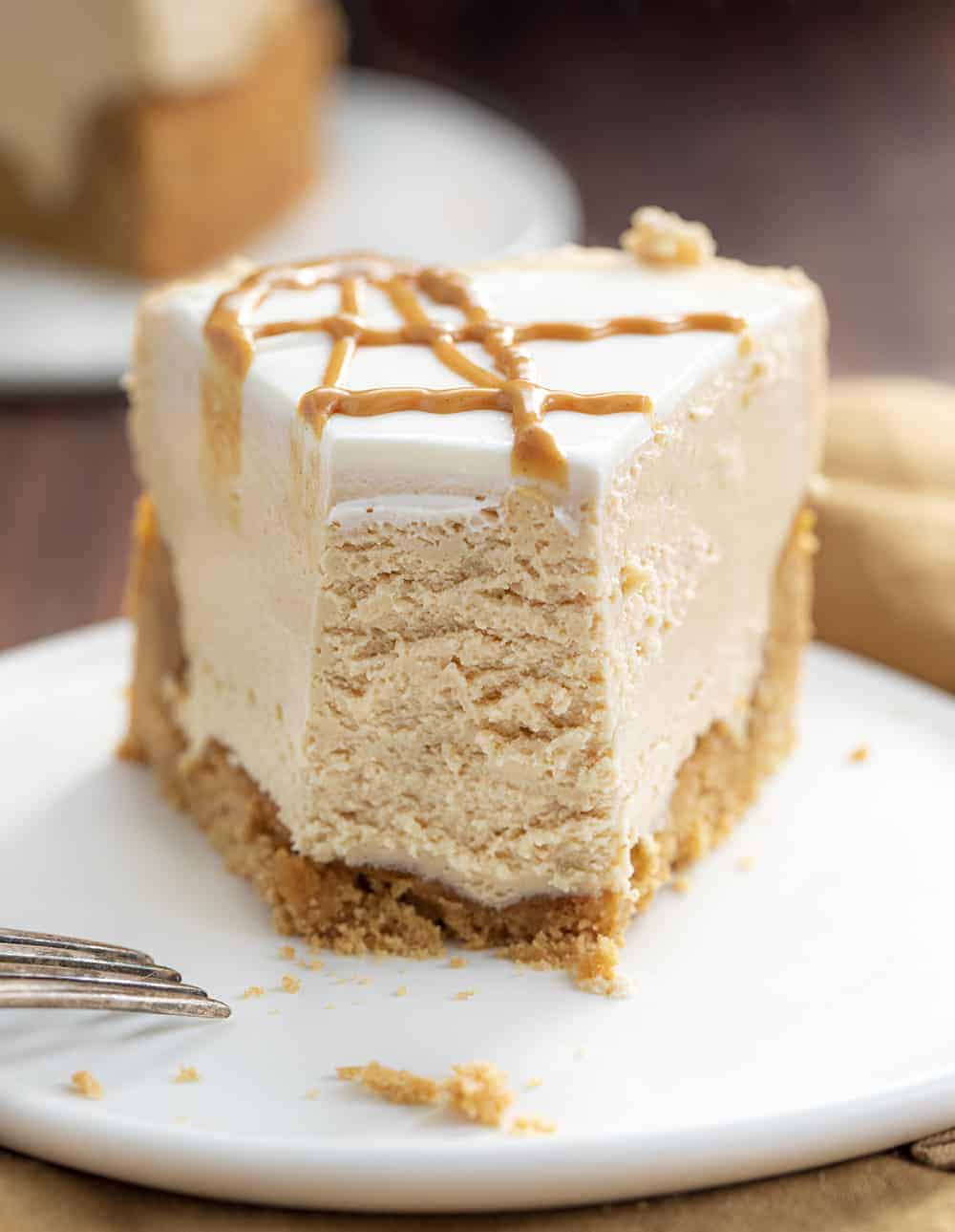 Peanut Butter Cheesecake is a smooth and creamy cheesecake made with peanut butter and a homemade peanut butter cookie crust. Peanut Butter Cheesecake, Decadent Cheesecake, Cheesecake Recipes, Peanut Butter Desserts, Dessert, Triple Peanut Butter Cheesecake, i am baker, iambaker, recipes, Christmas, New Years Eve Slice of Peanut Butter Cheesecake with Bite Missing