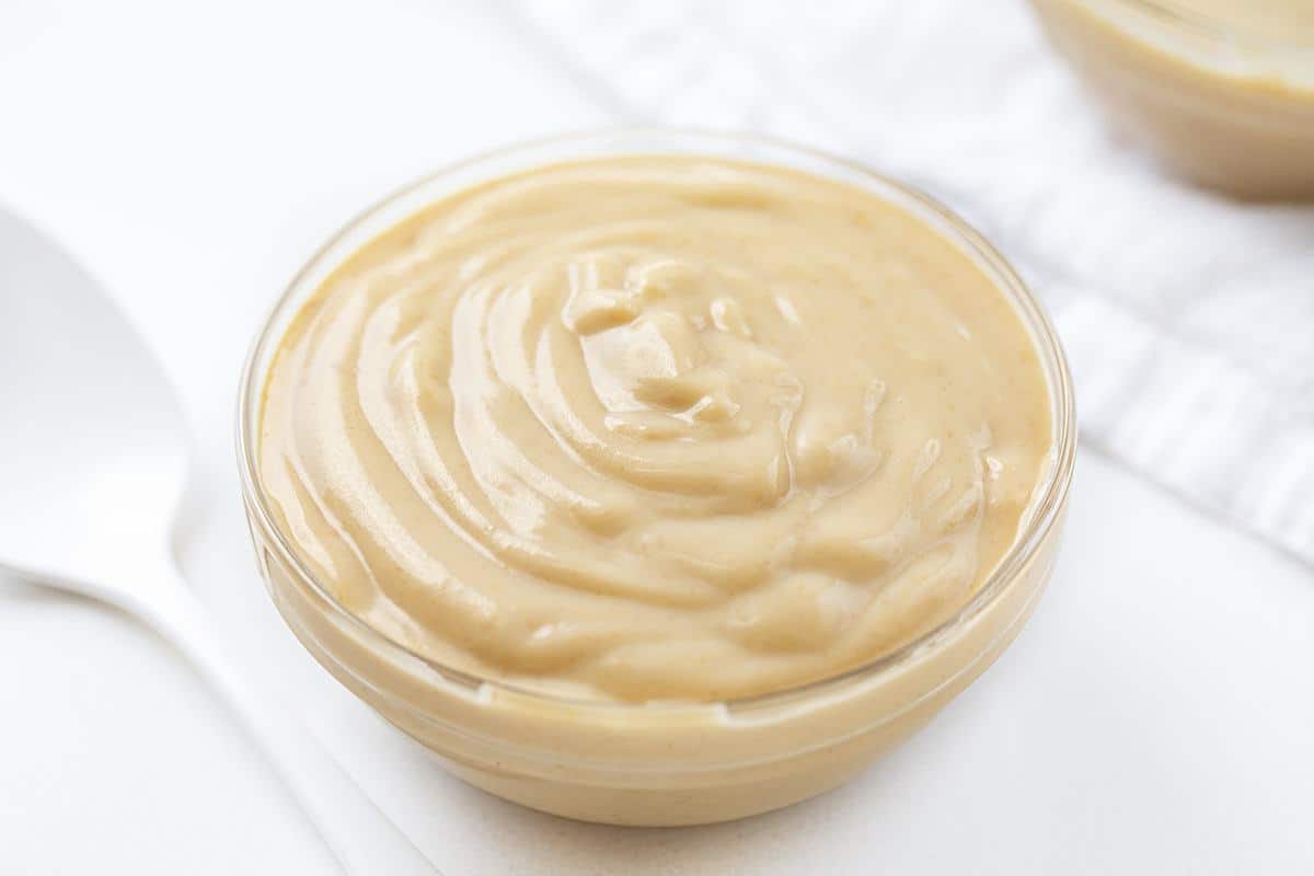 The best no-bake desserts to get your sweet tooth through the summer! no bake, no bake desserts, desserts, recipes, cheesecake, cookies, bars, cake, pudding, mousse, puppy chow, muddie buddies, rice krispy bars, dessert, memorial day dessert, labor day desserts, i am baker, iambaker Bowl of Homemade Peanut Butter Pudding with White Spoon.
