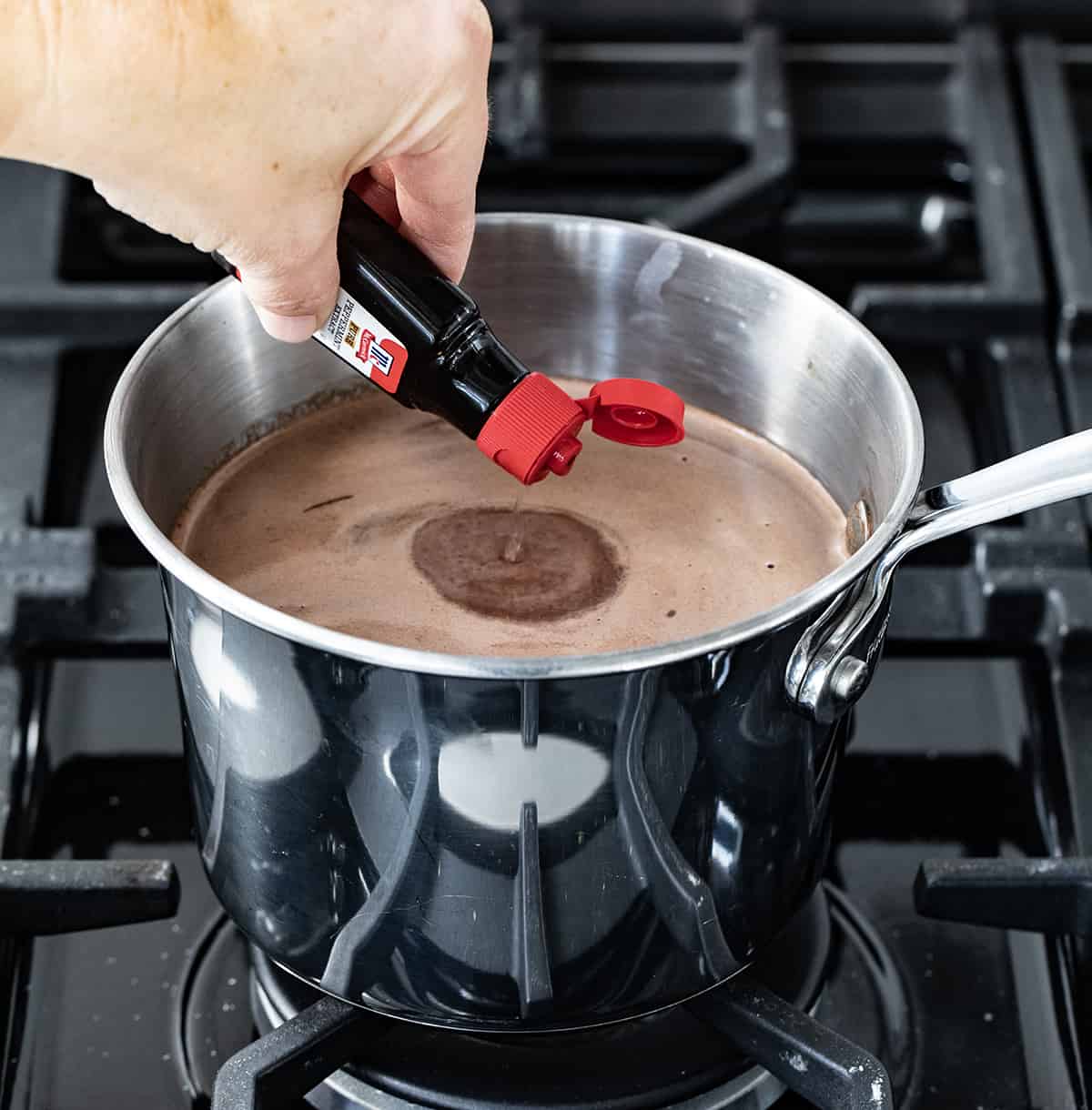 This creamy, smooth, velvety Peppermint Hot Chocolate is a Holiday must have! Just like we have a pumpkin spice season every Autumn, it seems to be peppermint season once we hit the holidays. With candy canes associated with Christmas, that peppermint flavor has been added to everything from cookies, to desserts, to candy, and drinks like this one. And, once you taste this peppermint hot chocolate, you will want to keep the recipe handy for any time you crave a minty chocolate treat. Adding Peppermint Extract to Melted Chocolate in a Saucepan.