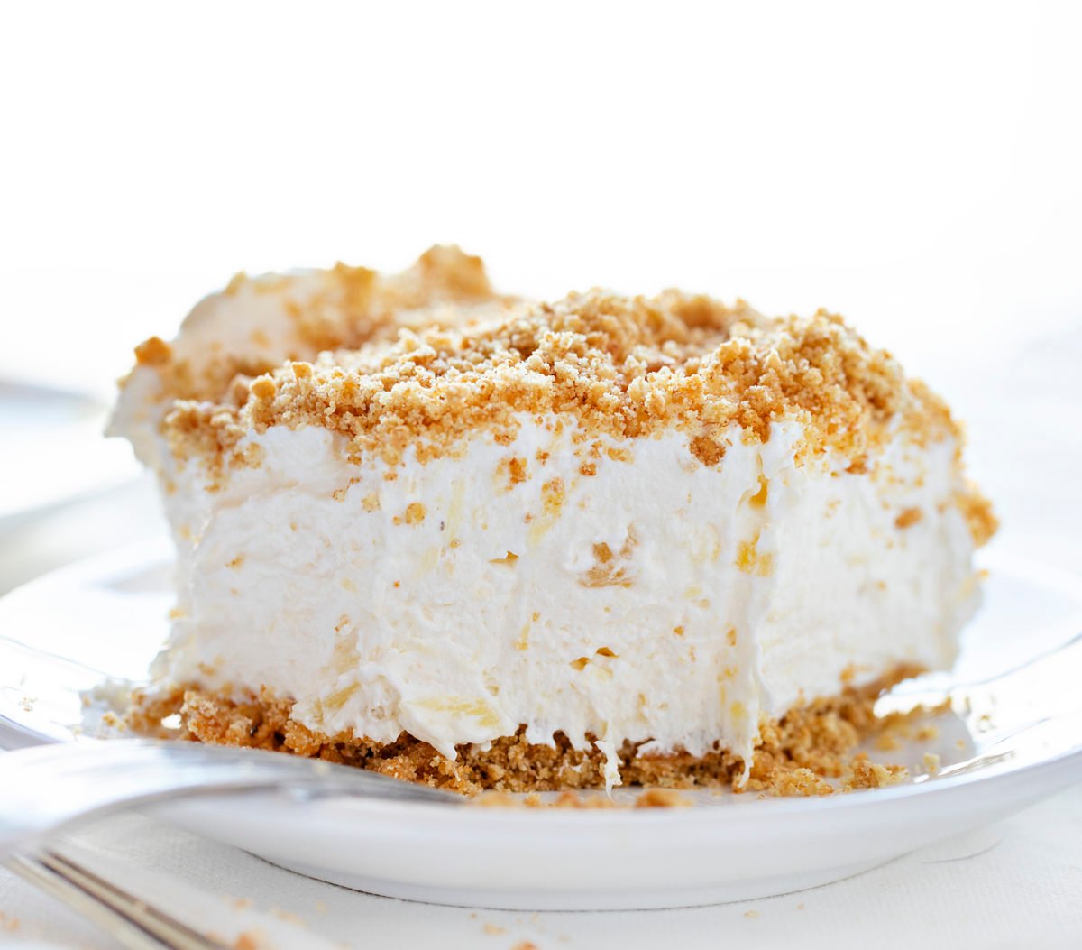 The best no-bake desserts to get your sweet tooth through the summer! no bake, no bake desserts, desserts, recipes, cheesecake, cookies, bars, cake, pudding, mousse, puppy chow, muddie buddies, rice krispy bars, dessert, memorial day dessert, labor day desserts, i am baker, iambaker Pineapple Dessert on a Plate with Bite Removed.