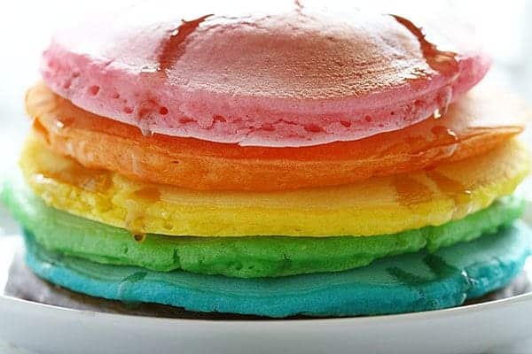 These colorful pancakes look like the rainbow and taste delicious! All you need is some food coloring and the best pancake recipes to start your day with some beauty! Tips on how to make the Perfect Rainbow Pancakes! #pancakes #rainbow