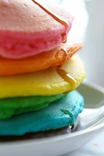 These colorful pancakes look like the rainbow and taste delicious! All you need is some food coloring and the best pancake recipes to start your day with some beauty! Tips on how to make the Perfect Rainbow Pancakes! #pancakes #rainbow