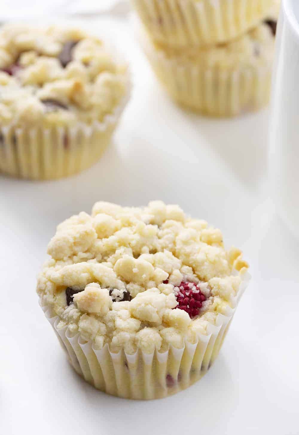Raspberry Chocolate Muffins are cream cheese muffins loaded with chocolate chunks and fresh raspberries, topped with a buttery crumb topping. Melt in your mouth deliciousness!! Muffins, Bakery Style Muffins, Raspberry Chocolate Muffins, Best Muffins, Muffin Recipes, Raspberry Muffins, Chocolate Muffins, i am baker, iambaker, baking, recipes Raspberry Chocolate Muffins on White Counter