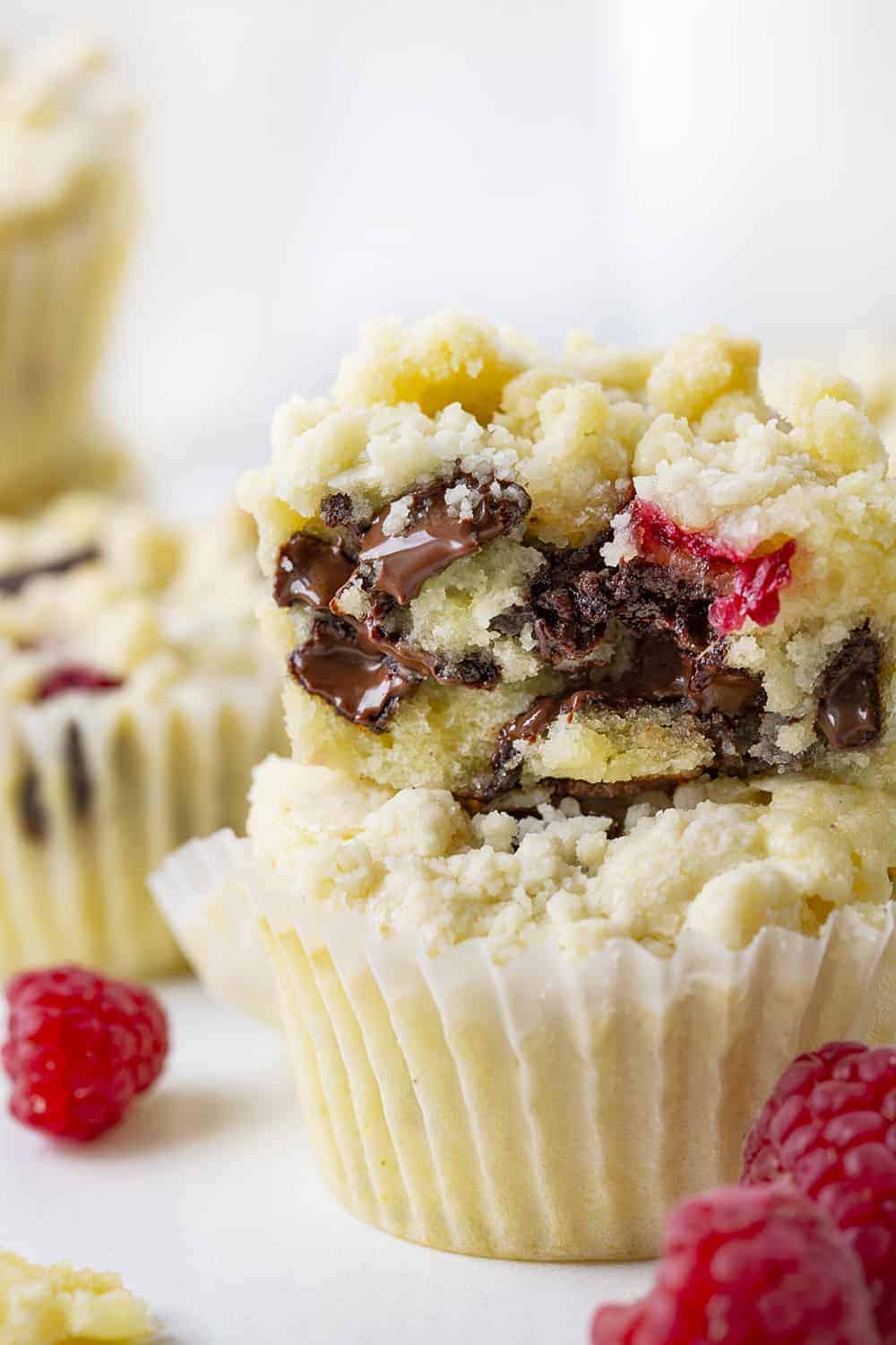 Raspberry Chocolate Muffins are cream cheese muffins loaded with chocolate chunks and fresh raspberries, topped with a buttery crumb topping. Melt in your mouth deliciousness!! Muffins, Bakery Style Muffins, Raspberry Chocolate Muffins, Best Muffins, Muffin Recipes, Raspberry Muffins, Chocolate Muffins, i am baker, iambaker, baking, recipes Raspberry Chocolate Muffin Stacked and Showing Inside