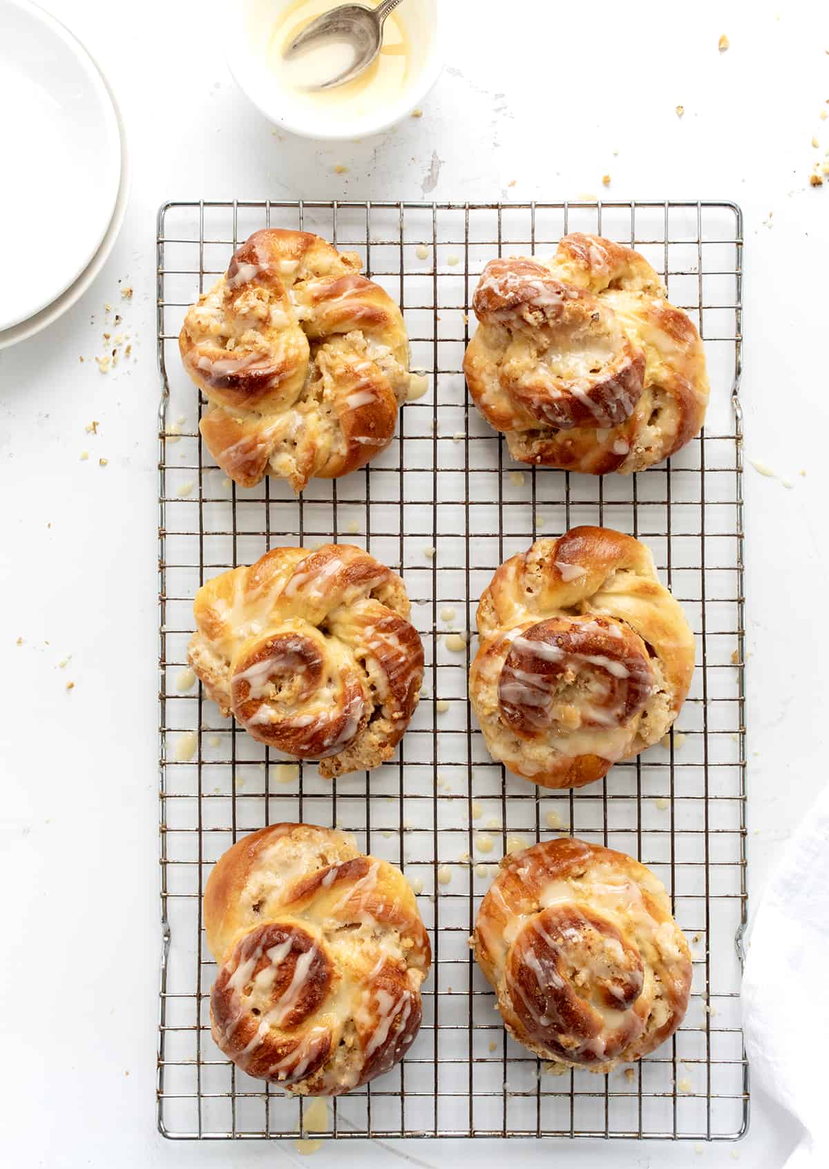 A Ring A Ling Pastry is a delicious and flavorful treat that combines a sweet dough with a nutty filling and tangy orange glaze. It's a copycat recipe from the 1955 Pillsbury Bake-Off winning recipe by Bertha Jorgensen. The spiral design is easy to do and gives you all the flavors of the pastry in every bite! Baked Ring A Ling Pastry on a Rack with Glaze from Overhead.