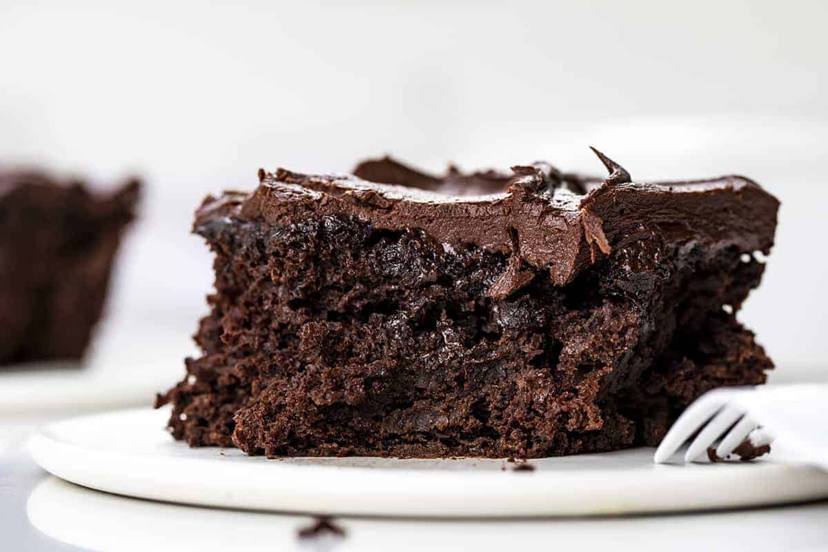 Chocolate Sauerkraut Cake is a soft and moist chocolate cake topped with a thick and creamy chocolate frosting. Chocolate Cake, Sauerkraut Cake, Chocolate Sauerkraut Cake, Vintage Cake, Old Fashioned Cake, Grandma's Chocolate Cake, Baking, Dessert, Chocolate Frosting, recipes, i am baker, iambaker Piece of Chocolate Sauerkraut Cake with a Bite Removed and Fork Resting on the Plate.