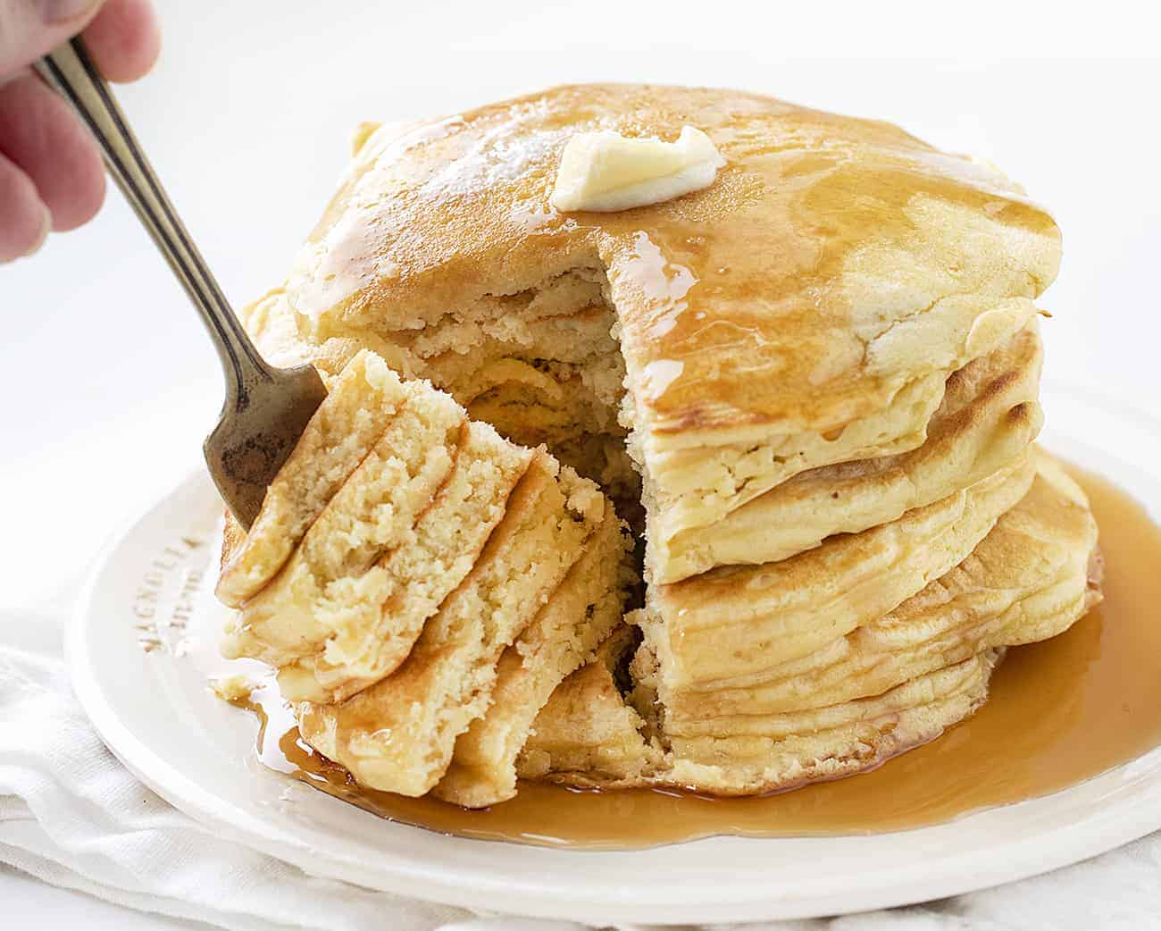 Using your sourdough starter, you can have light and fluffy Sourdough Pancakes ready to serve for a breakfast that will have everyone jumping out of bed! Breakfast, Pancakes, Sourdough Pancakes, How to Make Pancakes with Sourdough Discard, Sourdough Starter, The Best Pancakes, Sourdough Pancakes Recipe, i am baker, iambaker, pancakes Stack of Sourdough Pancakes with Fork Removing a Section
