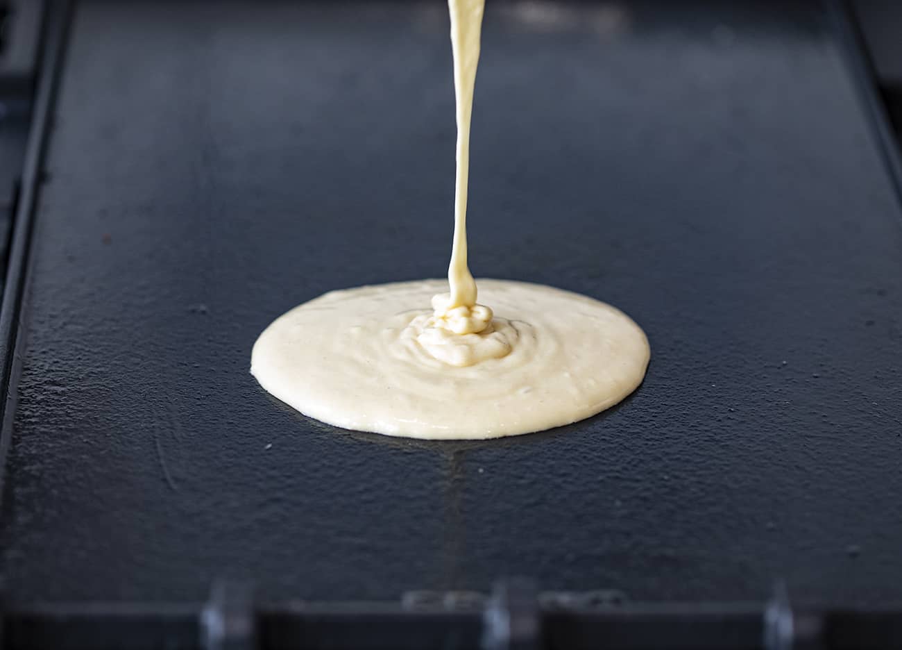 Using your sourdough starter, you can have light and fluffy Sourdough Pancakes ready to serve for a breakfast that will have everyone jumping out of bed! Breakfast, Pancakes, Sourdough Pancakes, How to Make Pancakes with Sourdough Discard, Sourdough Starter, The Best Pancakes, Sourdough Pancakes Recipe, i am baker, iambaker, pancakes Pouring Sourdough Pancake Batter on Hot Griddle
