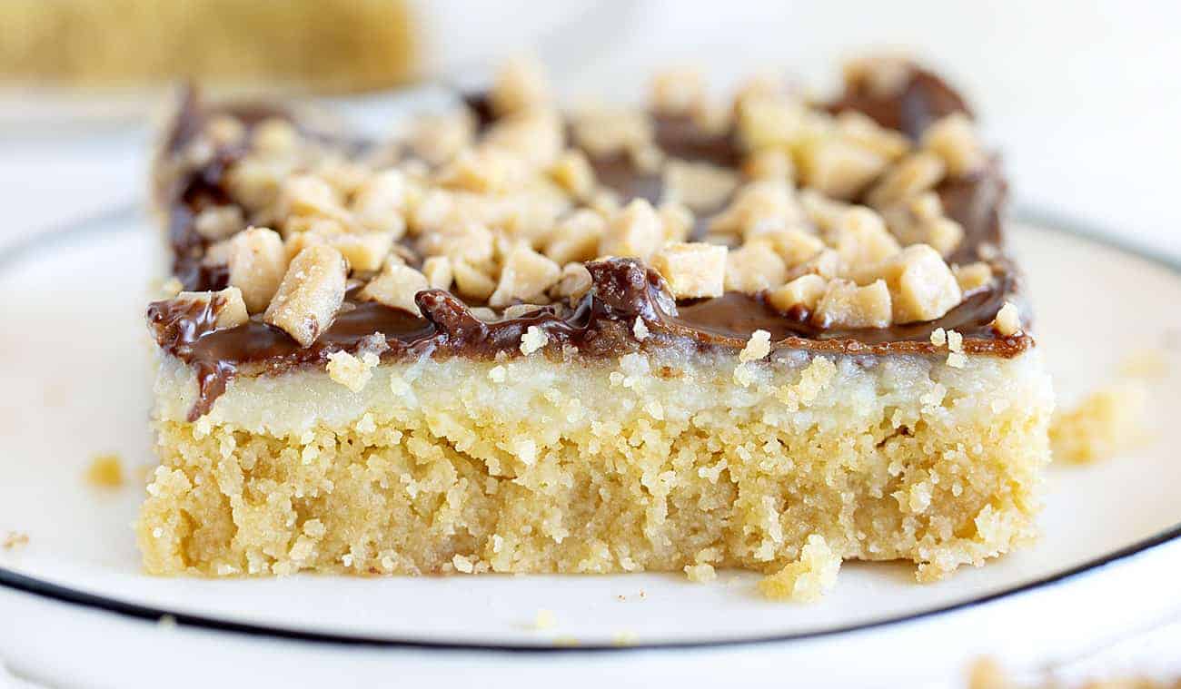 Chocolate Toffee Bars are a gooey delight with layers of flavor and satisfaction! iambaker, chocolate toffee bar, baking, desserts, chocolate toffee, toffee, dessert bars One Chocolate Toffee Bar on a Plate