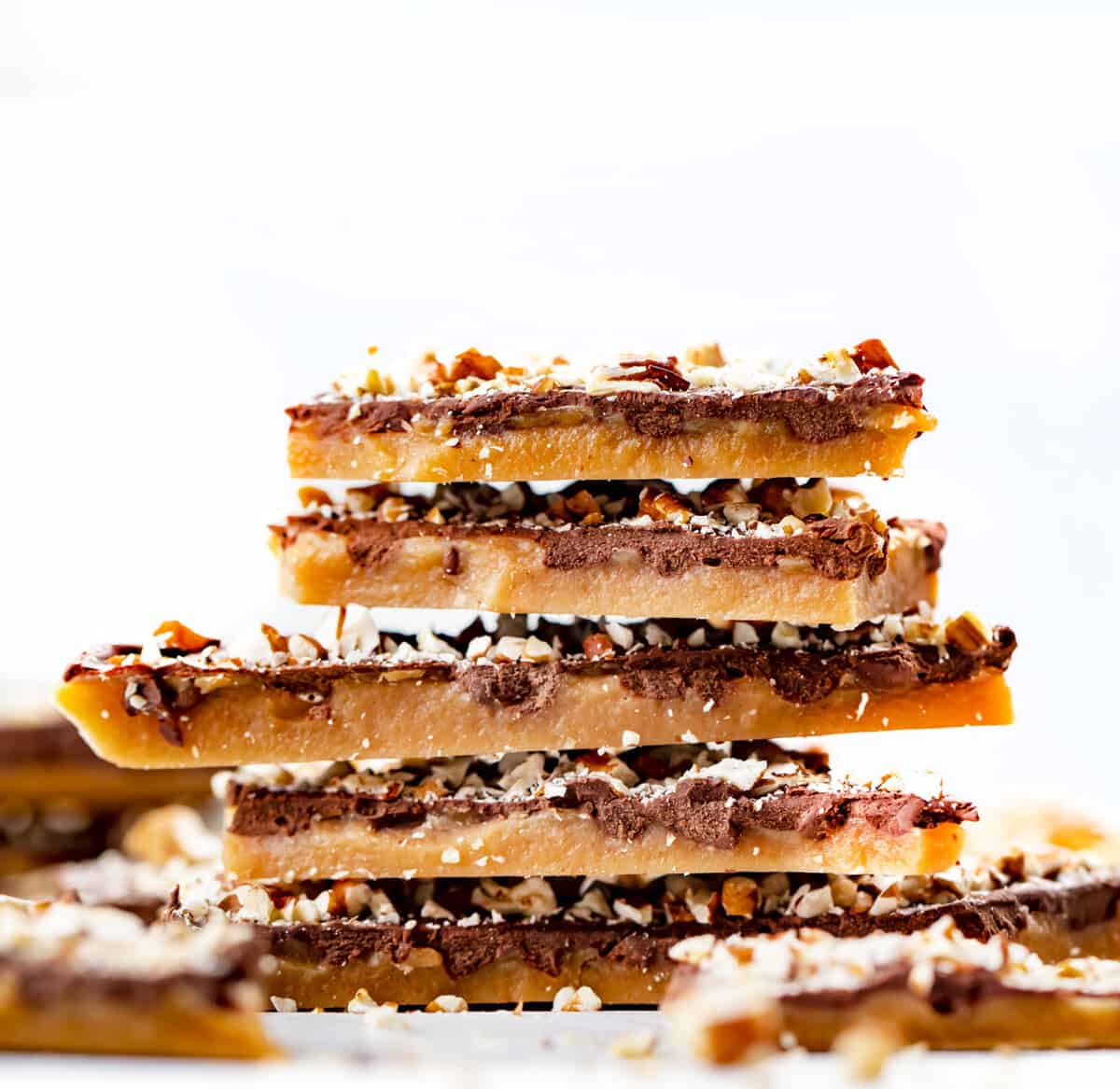 Learn how to make the BEST English Toffee that looks and tastes amazing! Rich buttery toffee covered with milk chocolate and chopped pecans. Just 4 ingredients! English toffee is the perfect holiday candy treat for parties and Christmas gifts. Stack of English Toffee Pieces.