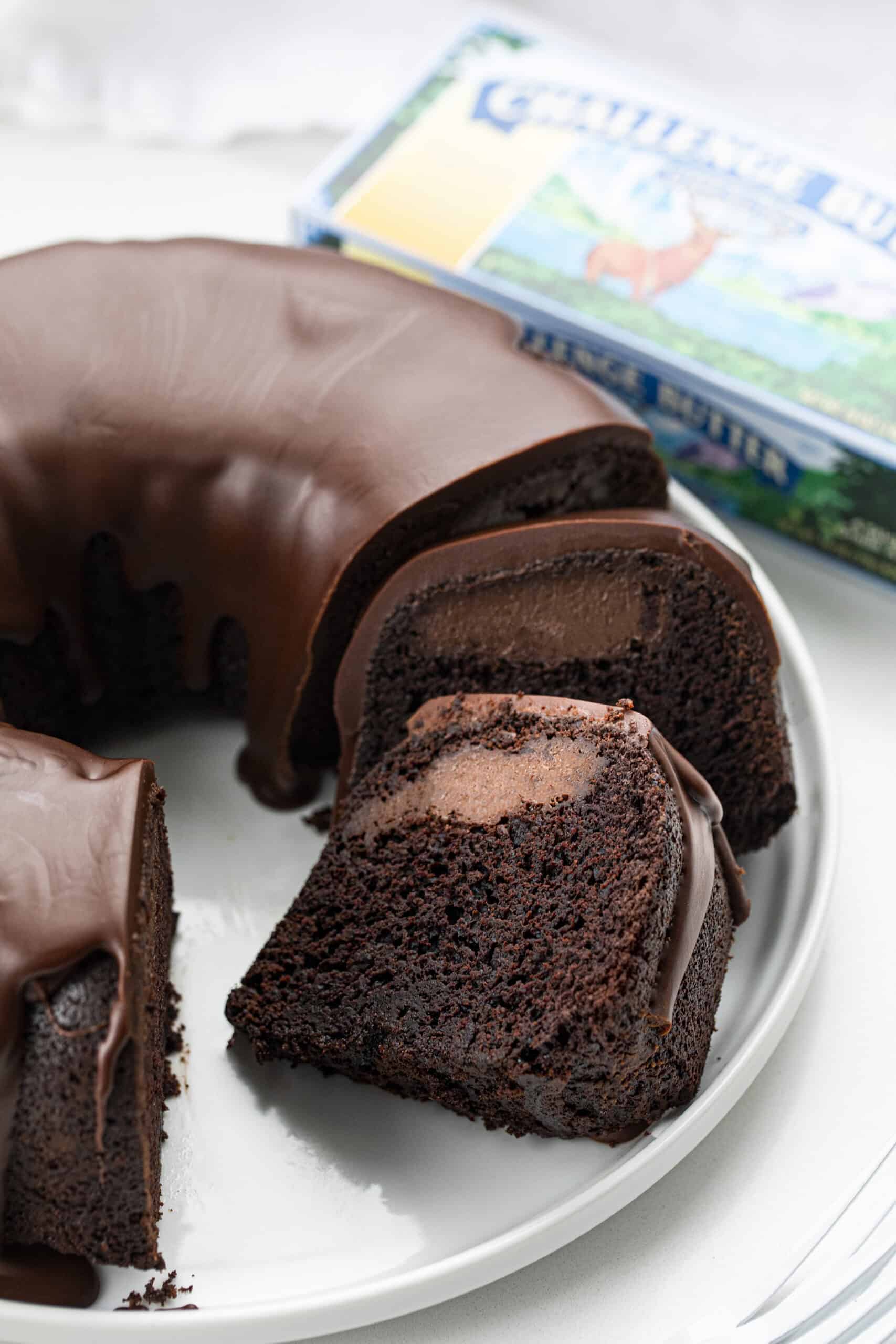 Death By Chocolate Bundt Cake is a chocolate cake with a chocolate cream cheese filling baked in a bundt pan and then topped with chocolate butter ganache. Chocolate Bundt, Triple Chocolate Bundt, Chocolate Cheesecake Chocolate Bundt, Death by Chocolate Bundt Cake, Butter Chocolate Ganache, How to Make Ganache with Just Butter, Chocolate Cream Cheese, Dessert, Baking, Decadent Dessert, Holiday Dessert, Christmas Dessert, New Years Dessert, i am baker, iambaker Pieces of Death by Chocolate Bundt Cake Sliced on Plate