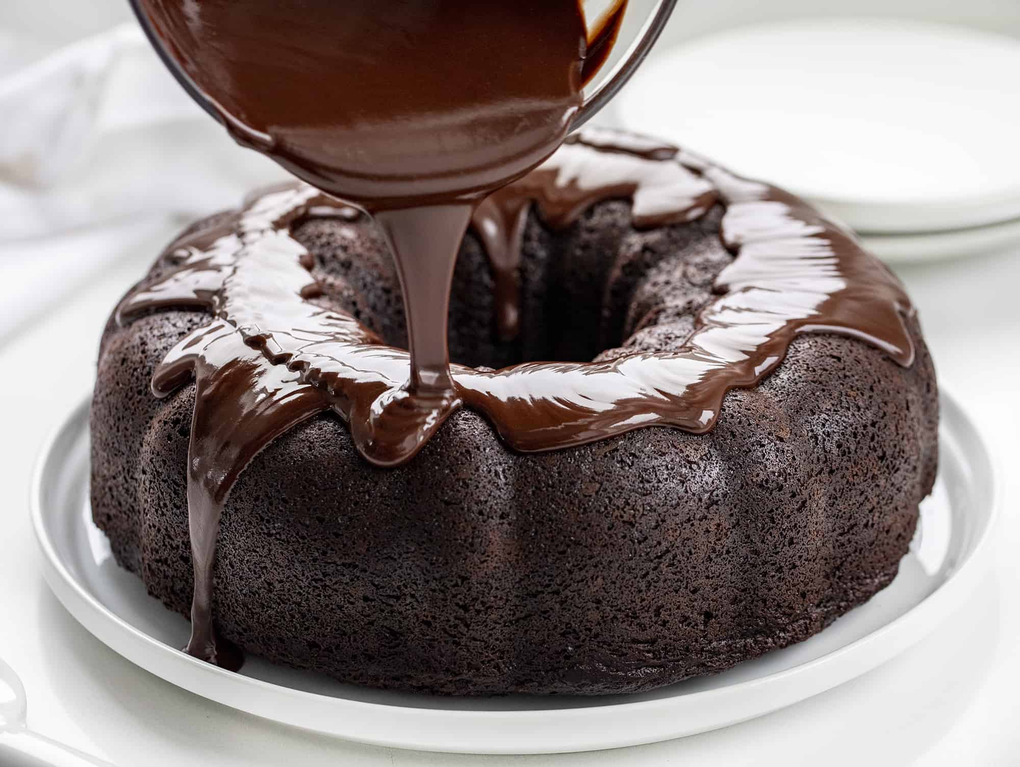 Death By Chocolate Bundt Cake is a chocolate cake with a chocolate cream cheese filling baked in a bundt pan and then topped with chocolate butter ganache. Chocolate Bundt, Triple Chocolate Bundt, Chocolate Cheesecake Chocolate Bundt, Death by Chocolate Bundt Cake, Butter Chocolate Ganache, How to Make Ganache with Just Butter, Chocolate Cream Cheese, Dessert, Baking, Decadent Dessert, Holiday Dessert, Christmas Dessert, New Years Dessert, i am baker, iambaker Adding Ganache to Chocolate Bundt Cake