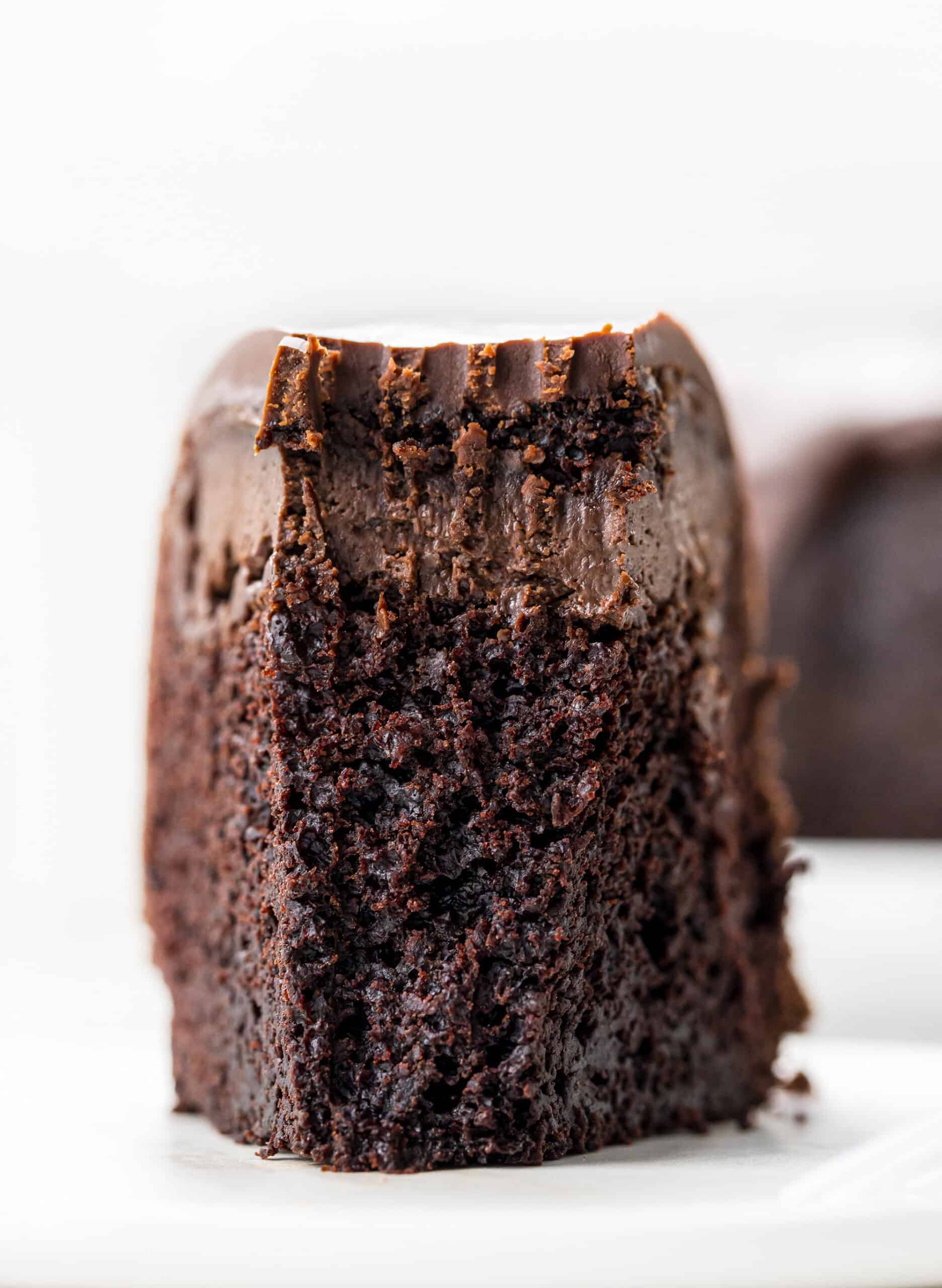 Death By Chocolate Bundt Cake is a chocolate cake with a chocolate cream cheese filling baked in a bundt pan and then topped with chocolate butter ganache. Chocolate Bundt, Triple Chocolate Bundt, Chocolate Cheesecake Chocolate Bundt, Death by Chocolate Bundt Cake, Butter Chocolate Ganache, How to Make Ganache with Just Butter, Chocolate Cream Cheese, Dessert, Baking, Decadent Dessert, Holiday Dessert, Christmas Dessert, New Years Dessert, i am baker, iambaker Slice of Death by Chocolate Bundt Cake with Bite Removed
