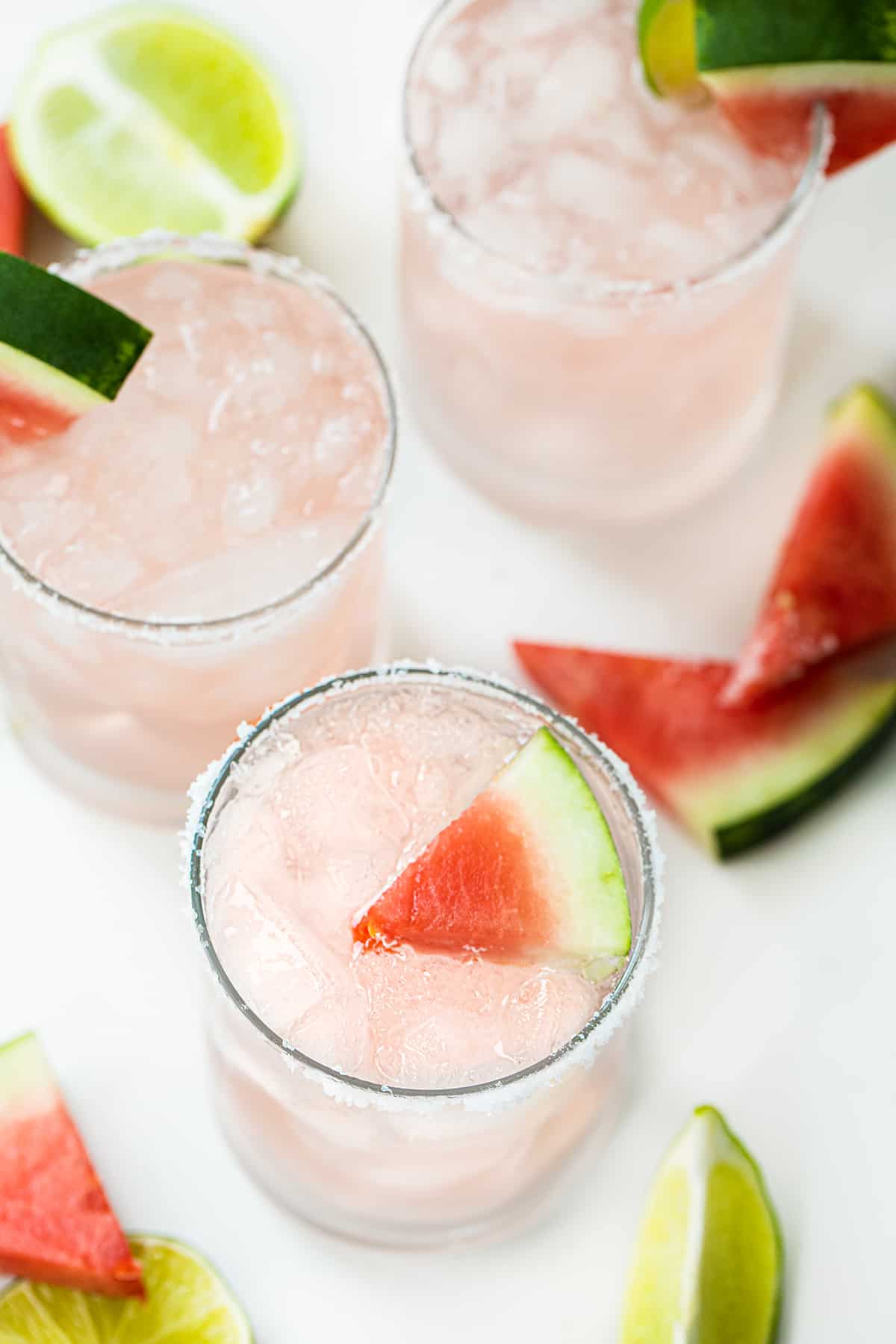 Watermelon Refresher is a delightful fizzy cocktail that combines the flavors of watermelon, lime, and a hint of tequila with a splash of Sprite. It's a perfect drink for a hot summer day, an outdoor gathering, or anytime you are craving a refreshing adult beverage! Glass Filled with a Watermelon Refresher Cocktail with a Watermelon Wedge and Lime.