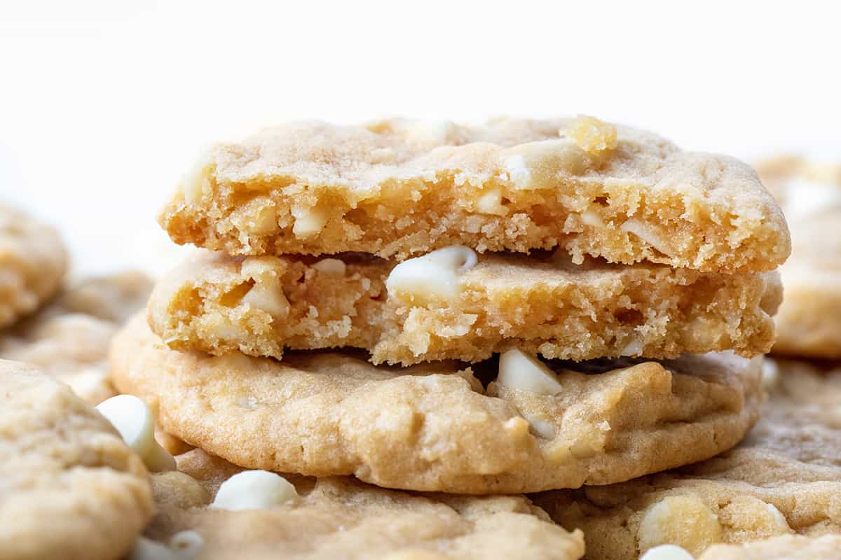 White Chocolate Macadamia Nut Cookies have the rich, buttery flavor of macadamia nuts and the sweet creaminess of white chocolate. These soft, chewy cookies are loaded with white chocolate chips and chopped macadamia nuts for the perfect balance of flavors, great for any occasion! Broken in Half White Chocolate Macadamia Nut Cookie Stacked.